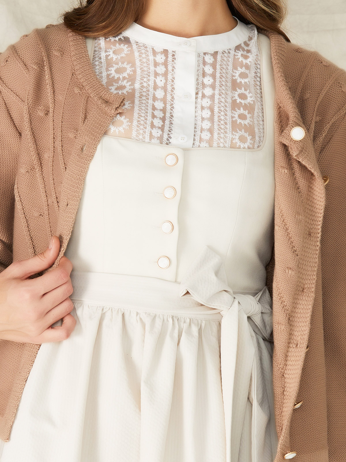 Ein modernes Dirndl aus braunem Krüger Samt mit feiner Strickbluse, perfekt für Herbstfestivals