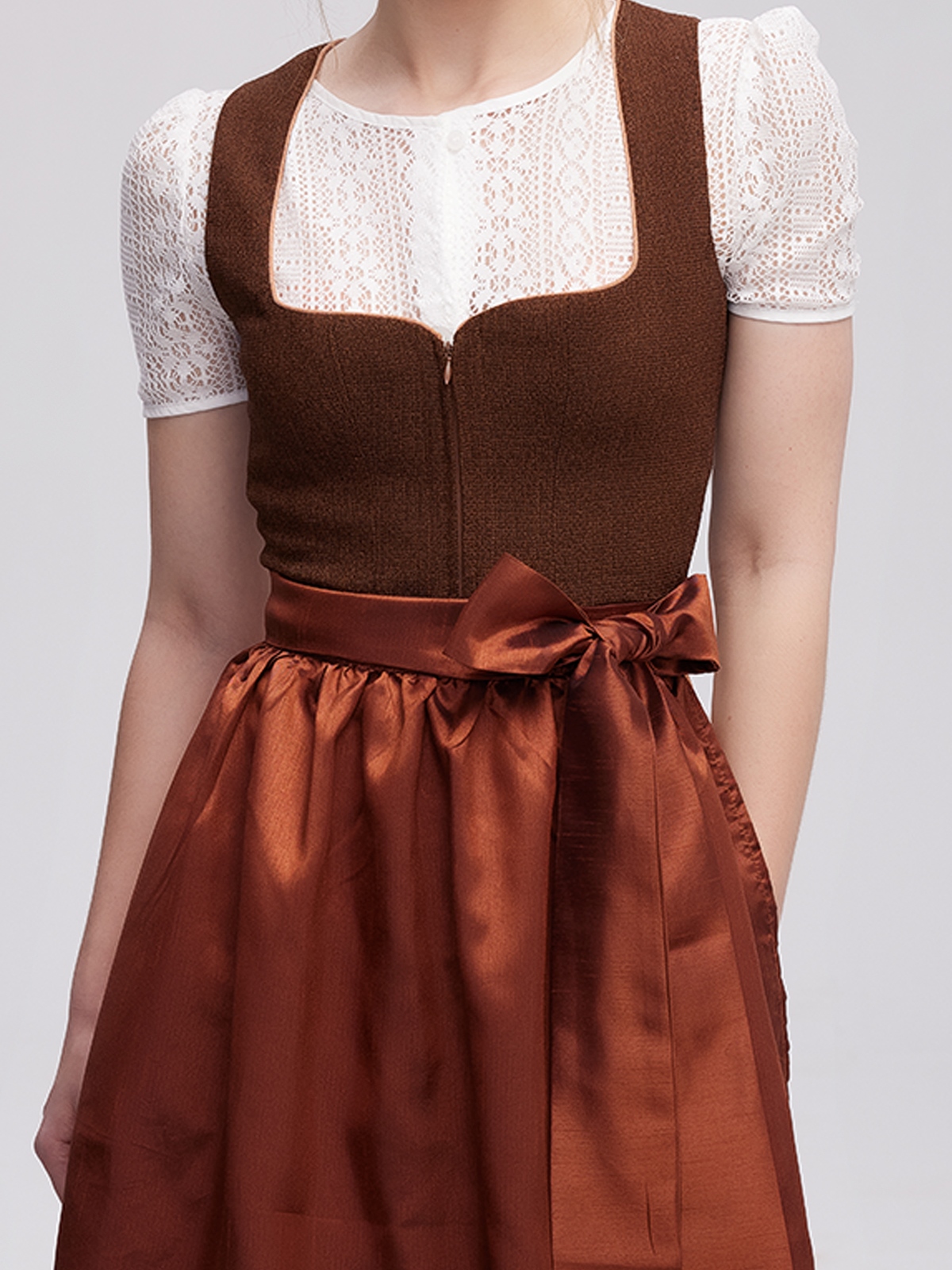 Ein elegantes weinrotes Dirndl mit traditioneller Schürze und passenden Accessoires